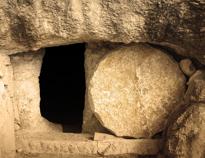 An old stone tomb with the stone rolled away.
