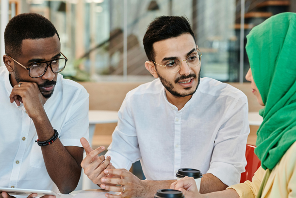 A woman and two men with different ethnicities joining in a serious discussion