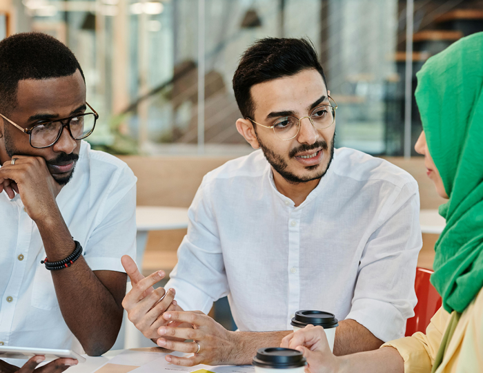 A woman and two men with different ethnicities joining in a serious discussion