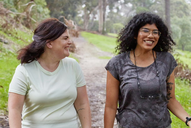Two women on a run smiling and chatting to each other