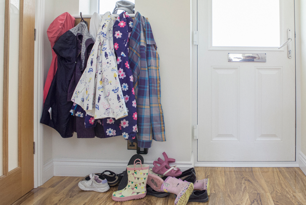 Family coats hanging up in a messy hallway
